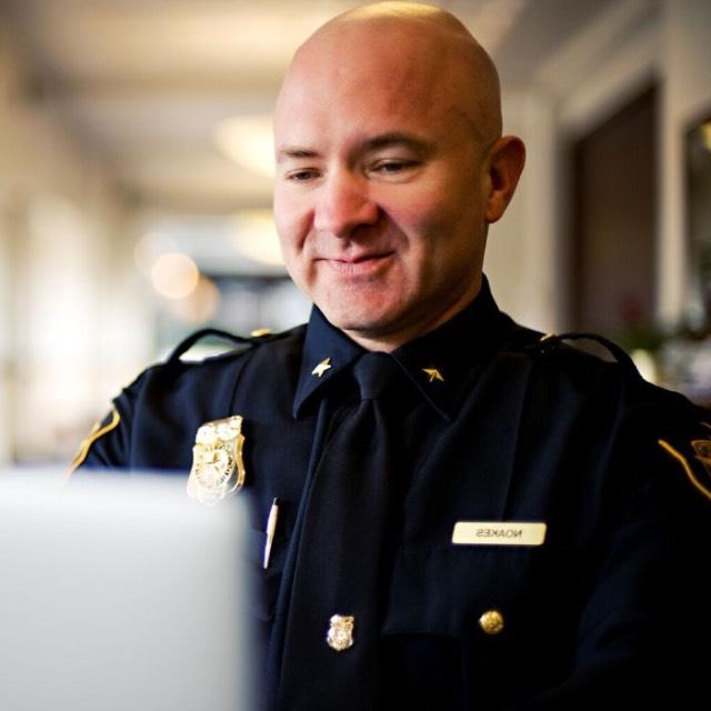 A TCU police officer works on a laptop computer